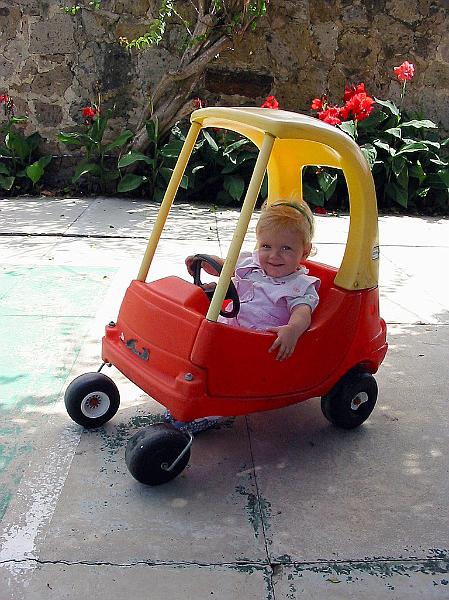 2-06.JPG - Riding in a little play car while visiting a friends home.