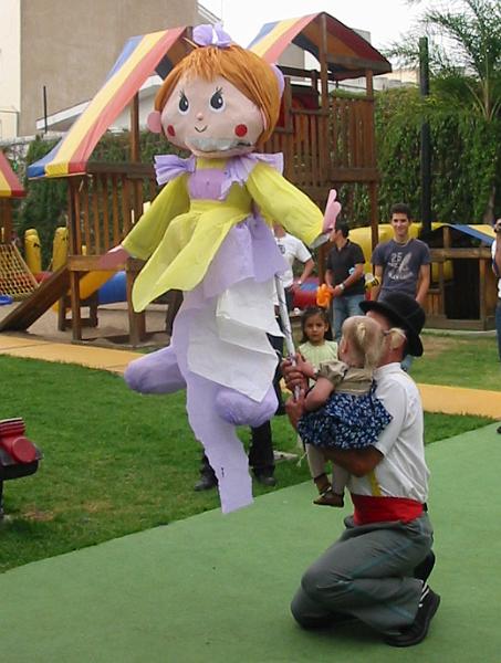 2-20.JPG - Ivo holding Kika up so she can take a swing at the piñata at a friend's birthday.