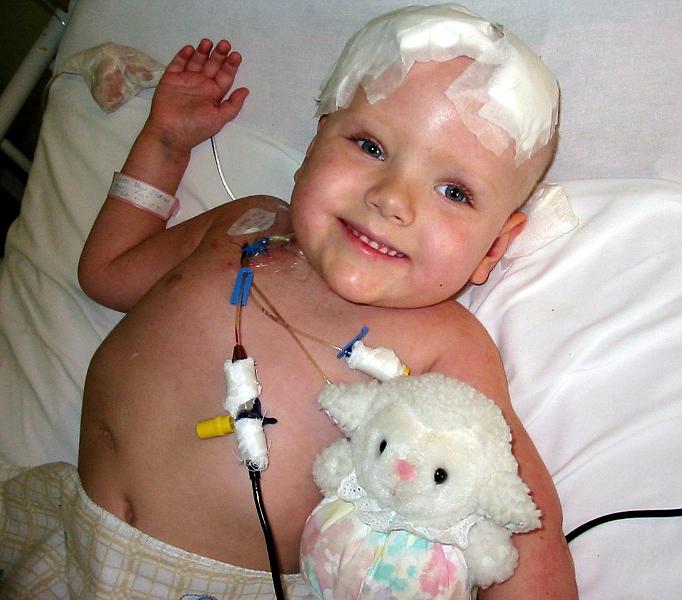 4-23.JPG - December 17, 2005 - Smiling through it all! Kika has three tubes coming from her heart catheter which are used for various intravenous purposes. The tube to the left of her head is from her external shunt.