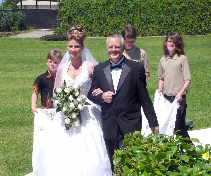 6-32.JPG - Dad leading Danni down the aisle while the brothers carry the train.